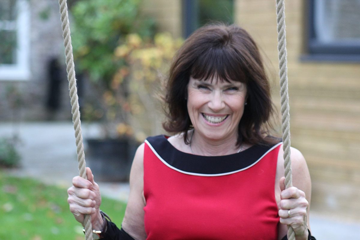 Client with a dark bob, outdoors on a garden swing
